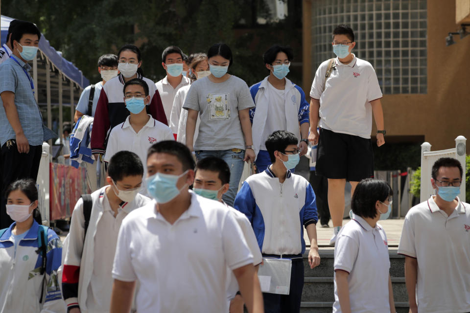 Students wearing face masks to protect against the new coronavirus leave school after finishing the first day of China's national college entrance examinations, known as the gaokao, in Beijing, Tuesday, July 7, 2020. China's college entrance exams began in Beijing on Tuesday after being delayed by a month due to the coronavirus outbreak. (AP Photo/Andy Wong)