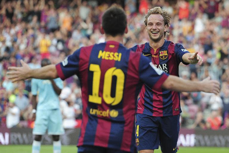 Barcelona's Croatian midfielder Ivan Rakitic (R) celebrates with Lionel Messi after scoring at the Camp Nou stadium in Barcelona on September 27, 2014