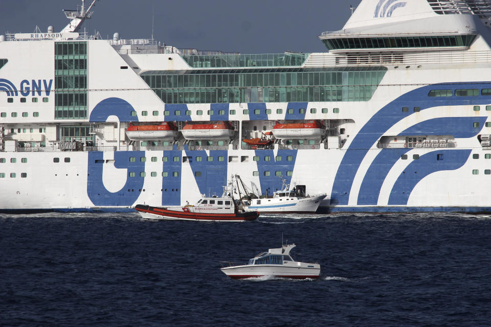 Migrants are embarked to the GNV Rhapsody ferry moored off Lampedusa island, Italy, Saturday, Sept. 5 , 2020. Italian officials have been hastily chartered ferries and put other measures into place to fight severe overcrowding at migrant centers on the tiny island of Lampedusa. (AP Photo/Mauro Seminara)