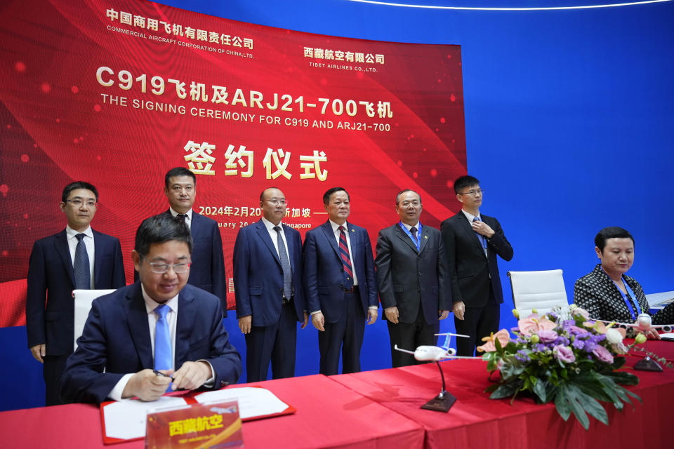 China’s COMAC Chairman He Dongfeng, center right at the background, witnesses a signing ceremony during the first day of the Singapore Airshow in Singapore, Tuesday, Feb. 20, 2024. (AP Photo/Vincent Thian)