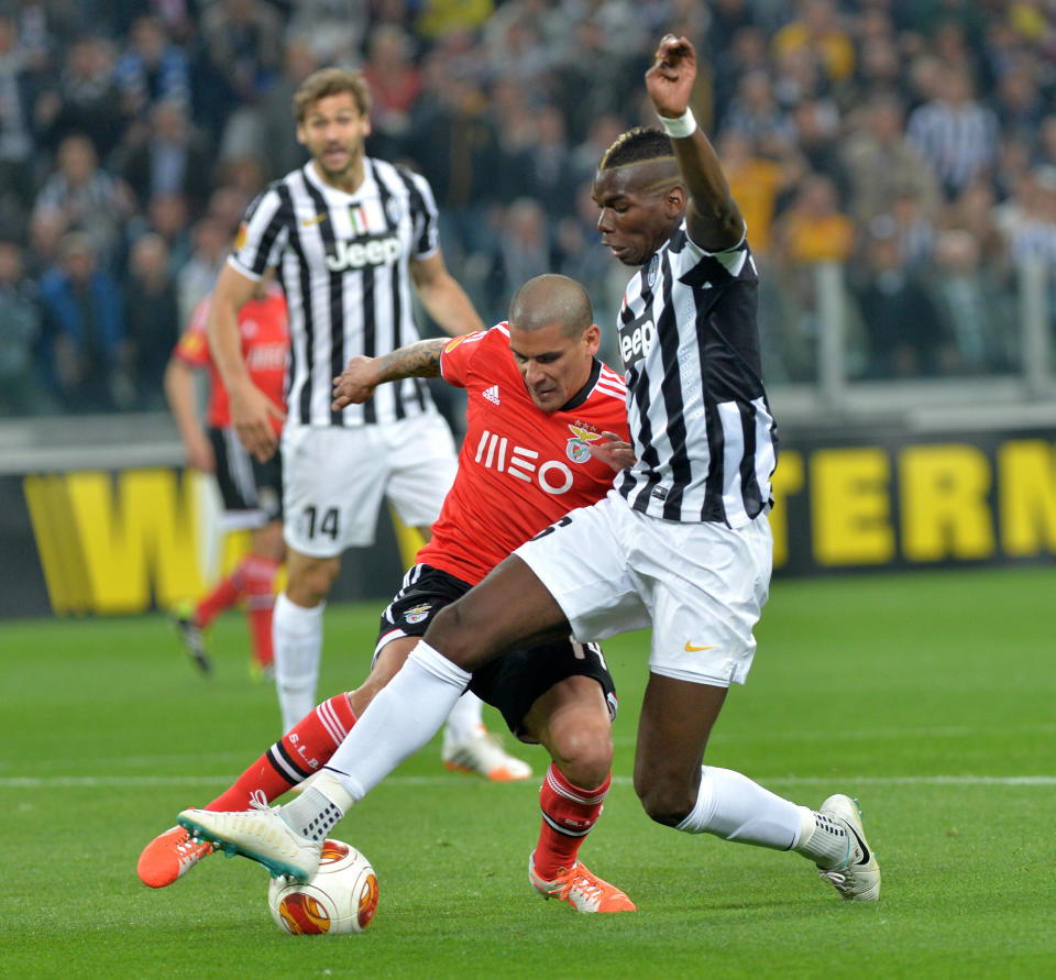 Juventus midfielder Paul Pogba, of France, right, challenges for the ball with Benfica defender Maxi Pereira during the Europa League semifinal second leg soccer match between Juventus and Benfica at the Juventus stadium, in Turin, Italy, Thursday, May 1, 2014. (AP Photo/ Massimo Pinca)