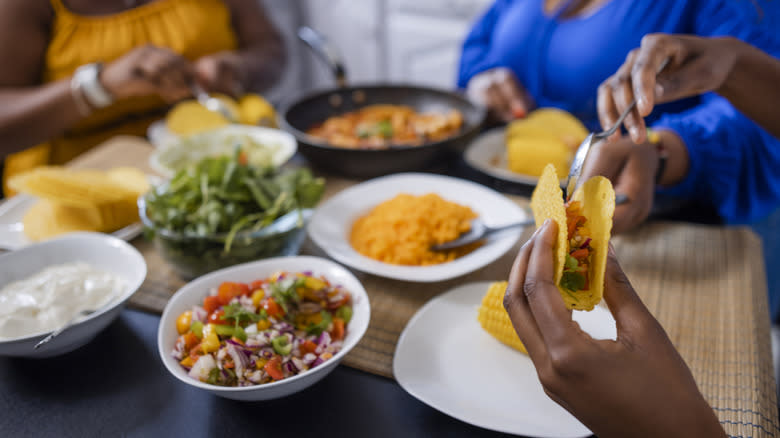person filling taco at table