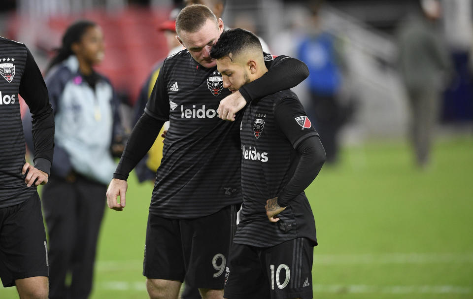 El inglés Wayne Rooney trata de consolar al argentino Luciano Acosta, su compañero en el D.C. UInited, tras la derrota por penales ante el Crew de Columbus, el jueves 1 de noviembre de 2018   (AP Foto/Nick Wass)