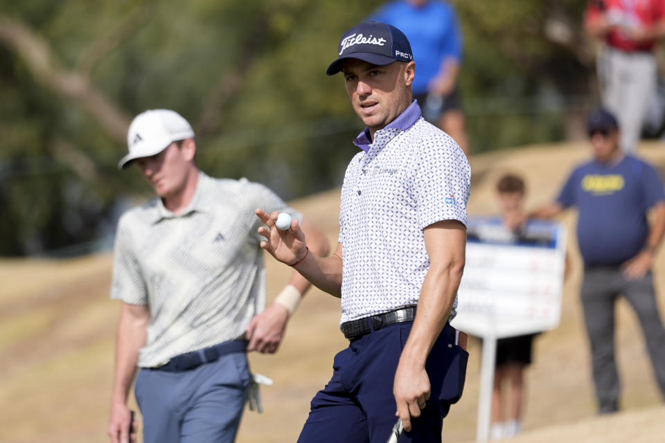 Justin Thomas, center, reacts to fans after completing the first hole of the Pete Dye Stadium Course during the final round of the American Express golf tournament, as Nick Dunlap, left, looks on, Sunday, Jan. 21, 2024, in La Quinta, Calif. (AP Photo/Ryan Sun)