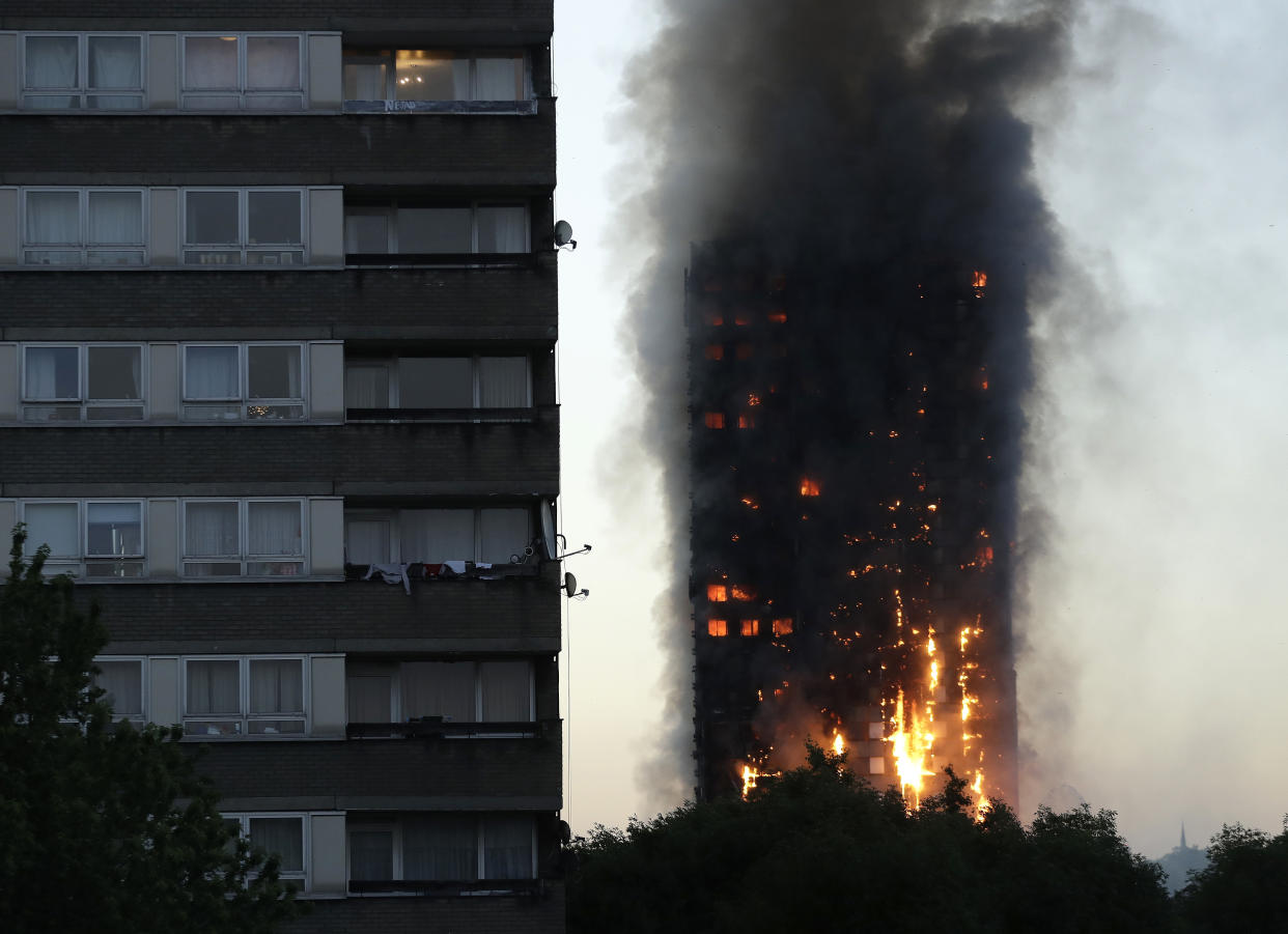 FILE - In this Wednesday, June 14, 2017 file photo smoke and flames rise from the Grenfell Tower high-rise building in west London. (AP Photo/Matt Dunham, File)