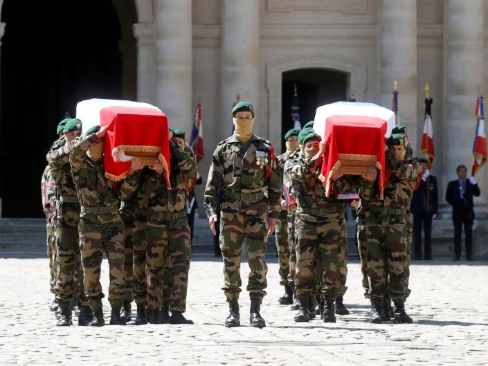 Special forces soldiers carry the flag-drapped coffins of late special forces soldiers Cedric de Pierrepont and Alain Bertoncello, who were killed in a night-time rescue of four foreign hostages including two French citizens in Burkina Faso last week, during a national tribute at the Invalides, in Paris, Tuesday, May 14, 2019.