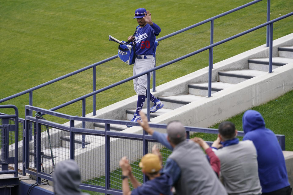 Los Angeles Dodgers right fielder Mookie Betts (50) waves to fans as he walks to the field before a spring training baseball game against the Milwaukee Brewers Tuesday, March 23, 2021, in Phoenix, Ariz. (AP Photo/Ashley Landis)