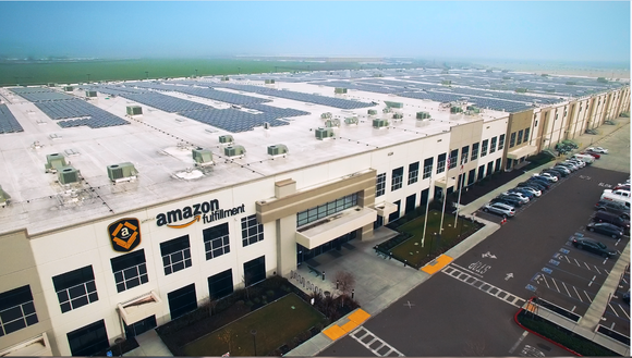 View from above of an Amazon fulfillment center, showing solar panels on roof.