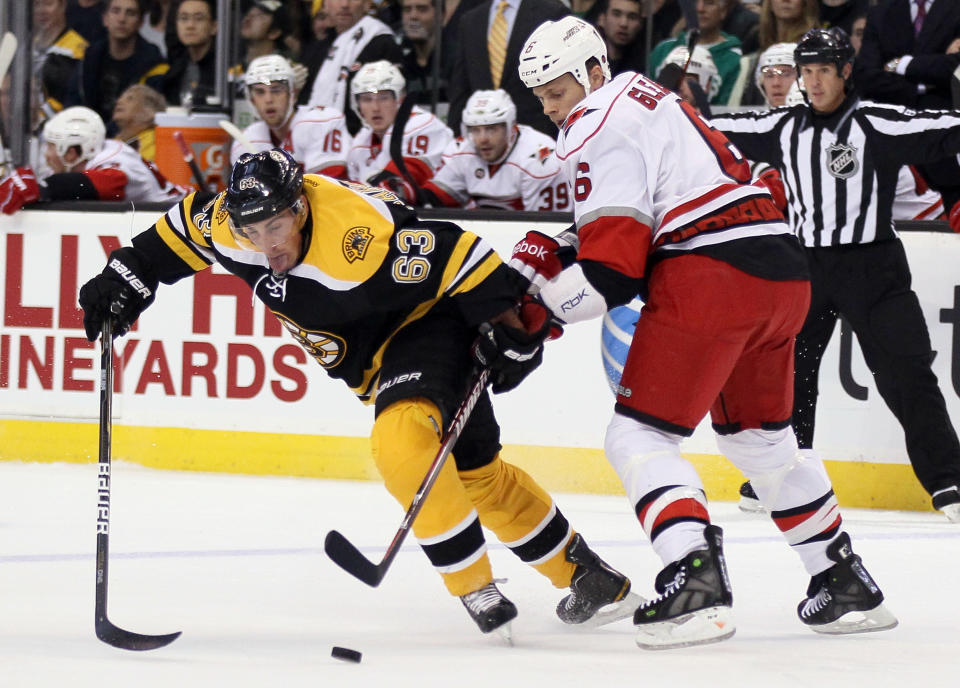 BOSTON, MA - OCTOBER 18: Brad Marchand #63 of the Boston Bruins and Tim Gleason #6 of the Carolina Hurricanes fight for the puck on October 18, 2011 at TD Garden in Boston, Massachusetts. (Photo by Elsa/Getty Images)