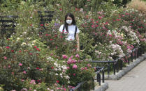 A woman wearing a face mask to protect against the spread of the new coronavirus visits a botanical garden in Tokyo, Monday, Aug, 10, 2020. (AP Photo/Koji Sasahara)