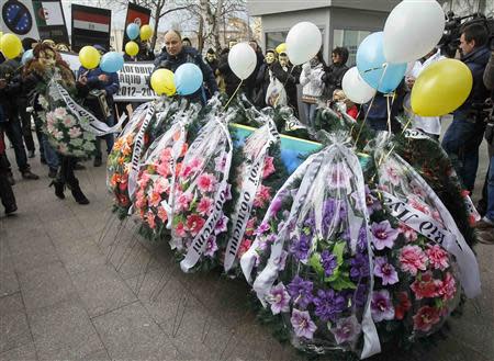 People lay wreaths near a coffin symbolising Ukraine's Euro-association near the EU Delegation building in Ukraine during a symbolic funeral procession and an anti-Europe rally in Kiev November 28, 2013. REUTERS/Gleb Garanich