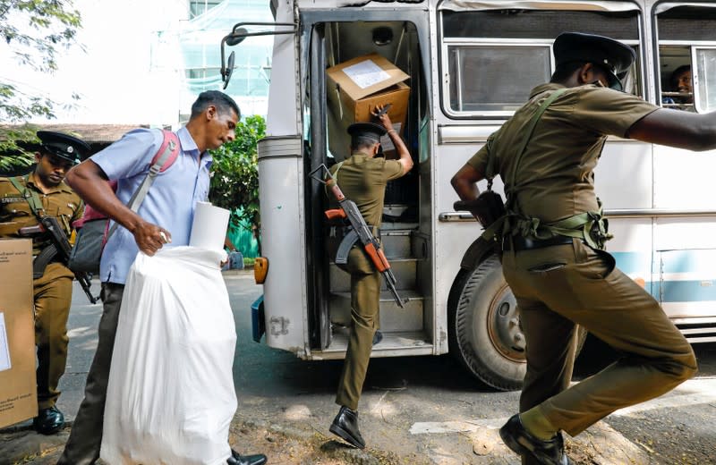 Sri Lankan police and election officials load ballot boxes and papers into busses from a distribution center to polling stations, ahead of country's presidential election scheduled on November 16, in Colombo