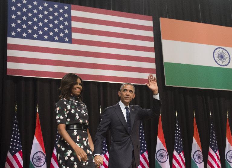 US President Barack Obama and First Lady Michelle Obama greet the audience after speaking on US-India relations, during a townhall event at Siri Fort Auditorium in New Delhi, on January 27, 2015