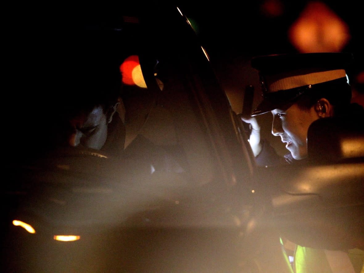 In this 2010 file photograph, a B.C. RCMP officer speaks with a motorist while looking for impaired drivers during a roadside check in Surrey, B.C. (Darryl Dyck/The Canadian Press - image credit)