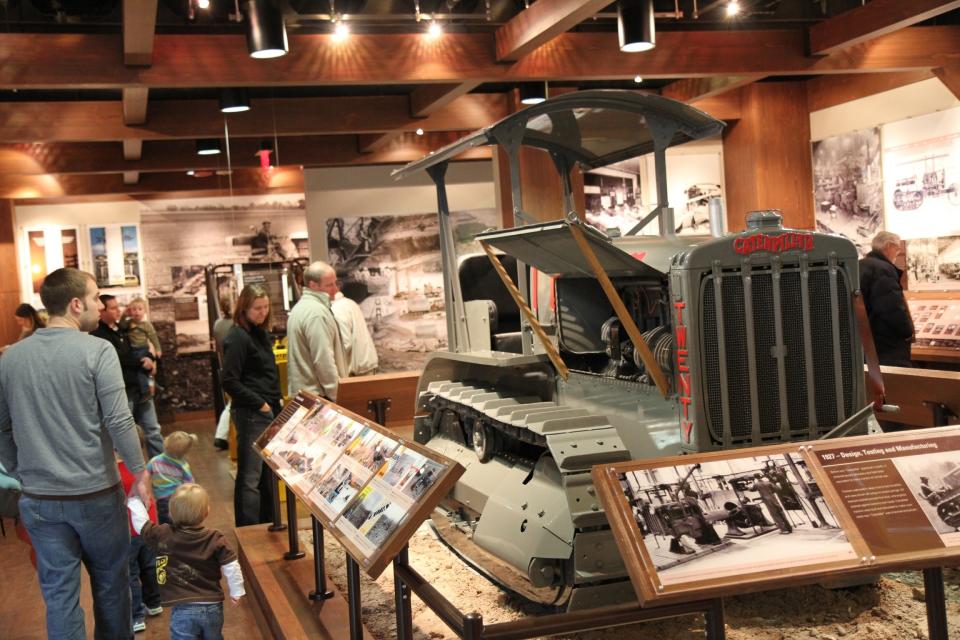 This December 2012 photo shows people touring the Caterpillar Visitors Center in Peoria, Ill. Caterpillar Inc. manufactures heavy equipment that bulldozes, digs, lifts and performs other tasks at construction and mining sites. The center lets visitors climb inside the machines for a closer look while computer simulations provide an opportunity to learn how to manipulate the controls. (AP Photo/Fritz Faerber)