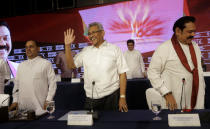 Sri Lankan presidential candidate and former defense chief Gotabaya Rajapaksa, center, waves as he leaves after addressing a news conference in Colombo, Sri Lanka, Tuesday, Oct. 15, 2019. Rajapaksa, who's a front-runner in next month's presidential election says if he wins he won't recognize an agreement the government made with the U.N. human rights council to investigate alleged war crimes during the nation's civil war. (AP Photo/Eranga Jayawardena)