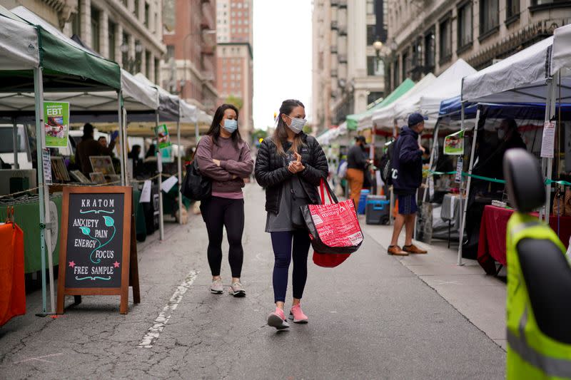 FILE PHOTO: Shoppers wearing protective masks walk through the Historic Downtown Farmers Market during the outbreak of the coronavirus disease (COVID-19) in Los Angeles, California