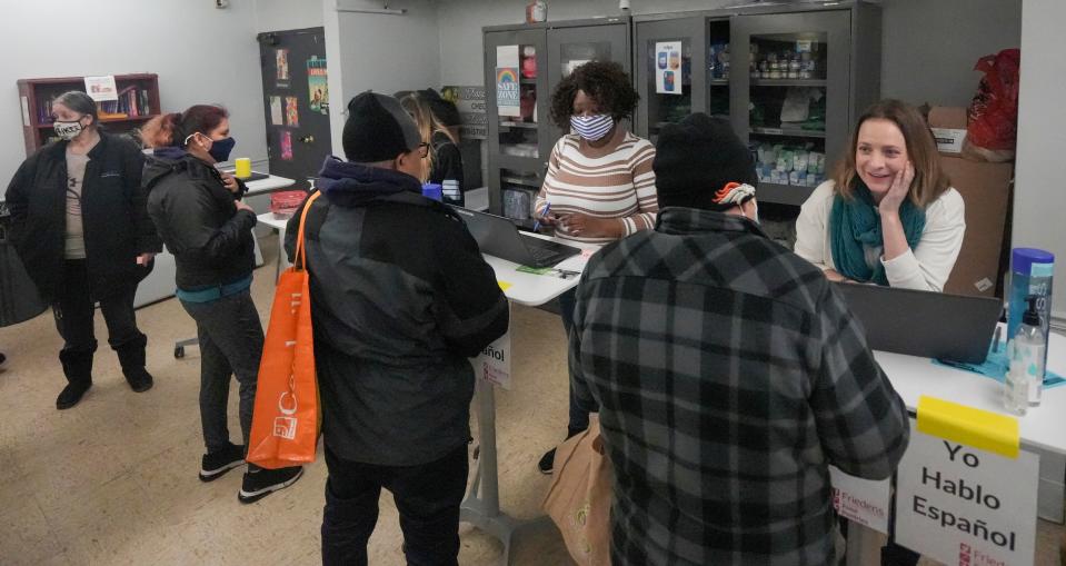 Aleka Shewczyk, right, and Bansierr Da, in the stripes, welcome pantry-goers as they go through the intake process Saturday, Jan. 21, 2023, at Despensa De La Paz in Milwaukee.