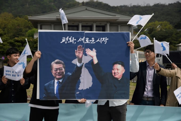 Activists hold a peace placard showing the leaders of North and South Korea at a rally in Seoul