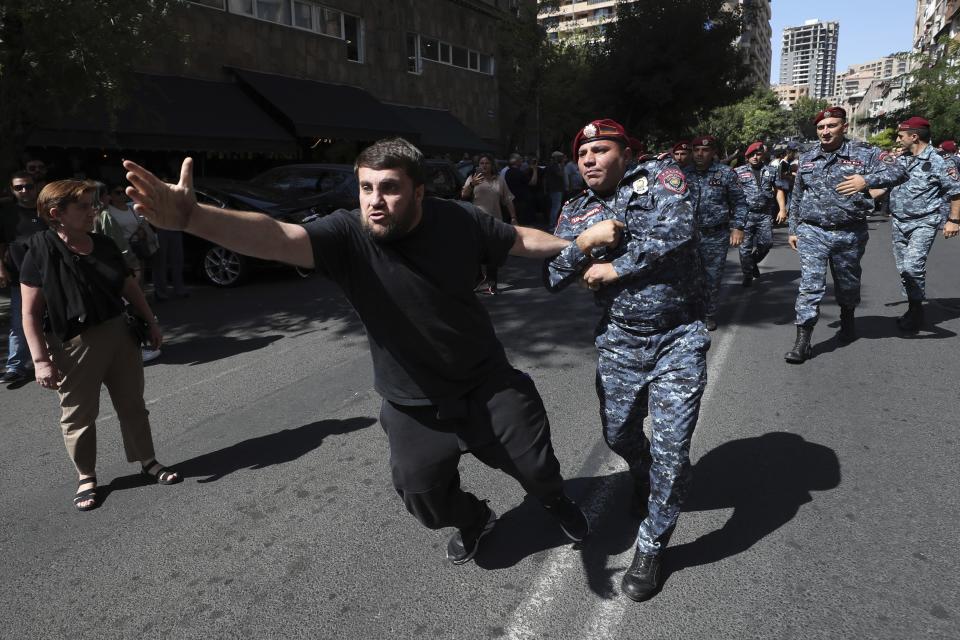 A oolicer officer tries to a detain a demonstrator during a protest against Prime Minister Nikol Pashinyan in Yerevan, Armenia, Friday, Sept. 22, 2023. (Stepan Poghosyan/Photolure via AP)