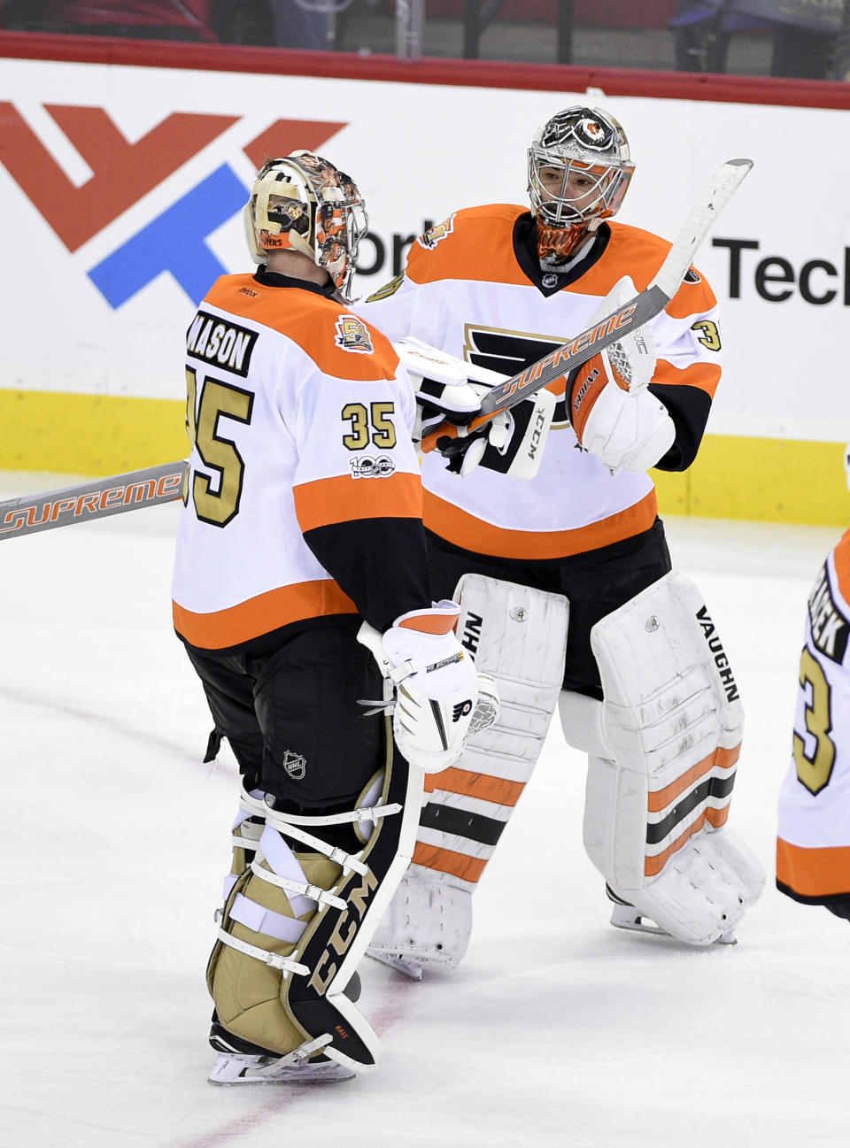 Philadelphia Flyers goalie Steve Mason (35) skates toward the bench as goalie Michal Neuvirth, right, of the Czech Republic, greets him after he was pulled during the third period of an NHL hockey game against the Washington Capitals, Sunday, Jan. 15, 2017, in Washington. (AP Photo/Nick Wass)
