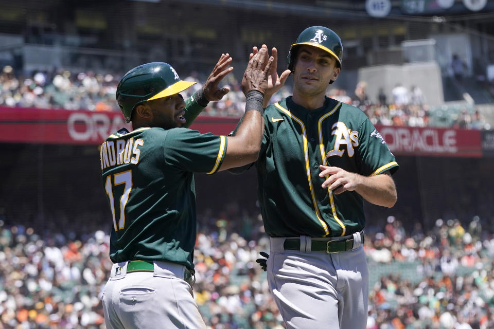 Oakland Athletics' Elvis Andrus, left, celebrates with Matt Olson after they scored on Matt Chapman's two-run single during the first inning of a baseball game against the San Francisco Giants in San Francisco, Sunday, June 27, 2021. (AP Photo/Jeff Chiu)