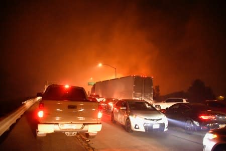 Freeway traffic comes to a standstill as a wind-driven wildfire burns in Sylmar, California