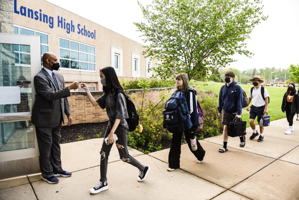 East Lansing High School Principal Andrew Wells welcomes students with a fist bump Thursday morning, May 19, 2022, as they enter the school. Every morning he greets and acknowledges each and every student as they arrive. After 33 years in education, he'll retire at the end of the academic year.