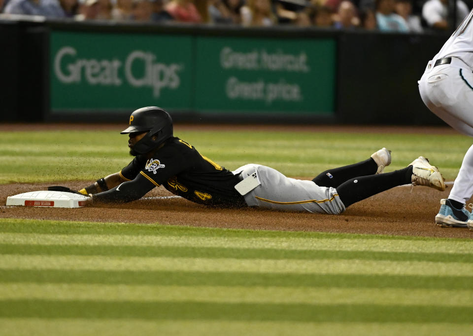 PHOENIX, ARIZONA - AUGUST 09: Rodolfo Castro #14 of the Pittsburgh Pirates slides into third base as his cell phone falls out of his pocket during the fourth inning of a game against the Arizona Diamondbacks at Chase Field on August 09, 2022 in Phoenix, Arizona. (Photo by Norm Hall/Getty Images)