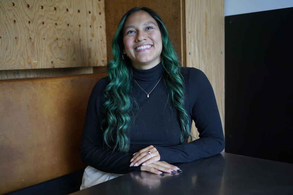 Daniella Malave, a recruiting analyst for Chipotle, poses for a photo at a Chipotle restaurant in Sea Girt, N.J., Thursday, Sept. 29, 2022. While working full time for the chain, Malave completed two years of community college with annual stipends of $5,250 from Chipotle. After that, she enrolled in the company’s free online college program, through which she earned a bachelor’s degree in business management from Wilmington University in 2020. (AP Photo/Seth Wenig)