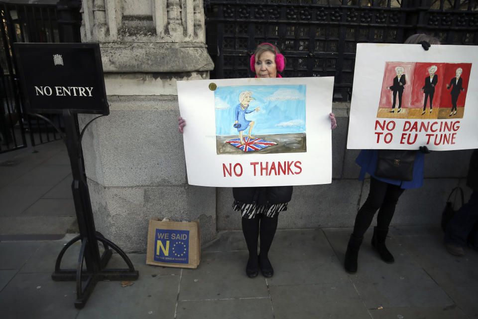 Pro-Brexit demonstrators who oppose British Prime Minister Theresa May, hold placards outside the Houses of Parliament, in London, Wednesday December 12, 2018. British Conservative lawmakers forced a no-confidence vote in Prime Minister Theresa May for Wednesday, throwing U.K. politics deeper into crisis and Brexit further into doubt. (AP Photo/Tim Ireland)