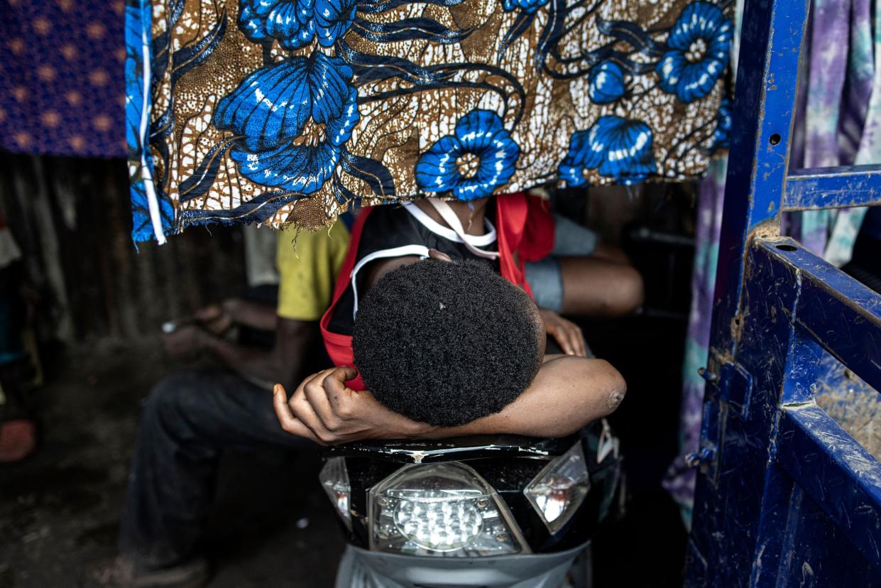 A man sleeps on a motorbike inside a drug den at the Kington landfill site in Freetown on June 21, 2023.