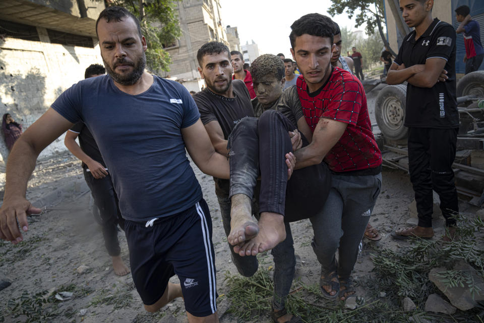 Palestinos llevan a un herido en un ataque aéreo israelí en Khan Younis, en la Franja de Gaza, el lunes 16 de octubre de 2023. (AP Foto/Fatima Shbair)