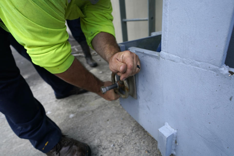 Workers for the Southeast Louisiana Flood Protection Authority - West close floodgates in Harvey, La., just outside New Orleans, Monday, Aug. 24, 2020, in advance of Tropical Storm Marco, expected to come near the Southern Louisiana coast. (AP Photo/Gerald Herbert)