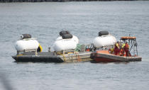 FILE-The Titan launch barge is moved to the Coast Guard yard at port in St. John's, Newfoundland in this June 24, 2023, file photo. The deadly implosion of an experimental submersible en route to the deep-sea grave of the Titanic last June has not dulled the desire for deep-sea exploration. Tuesday, June 18, 2024, marks one year since the Titan vanished on its way to the historic wreckage site. (Adrian Wyld/The Canadian Press via AP, file)