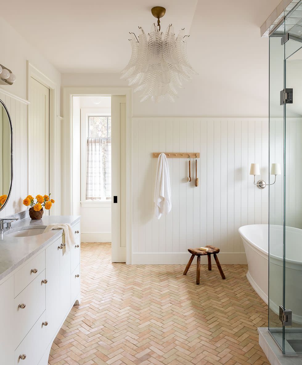 a bathroom with a tub sink and a chandelier