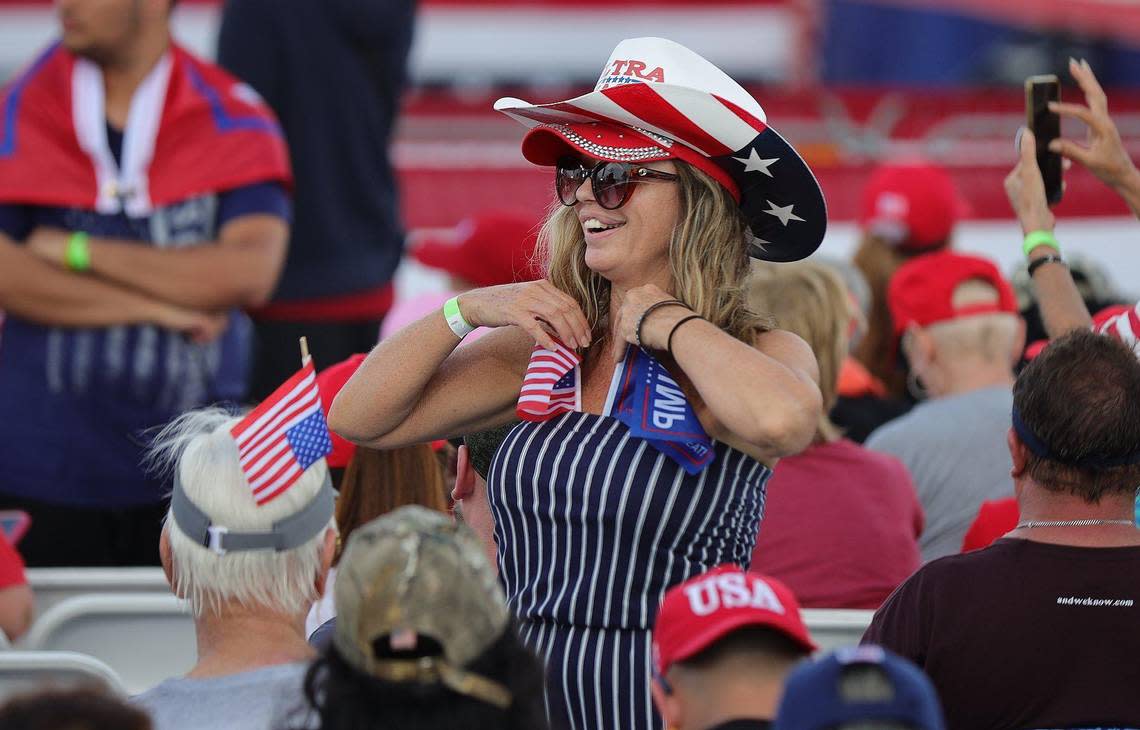 A Trump supporter adjust flags she tucked into her shirt at a rally at the Youth Fairgrounds in Miami. On Sunday, November 6, 2022 former President Donald Trump and a collection of other national and local Republicans campaign with U.S. Sen. Marco Rubio on the eve of the Nov. 8 election. Carl Juste/cjuste@miamiherald.com