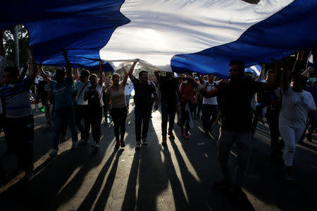 Demonstrators hold up a large Nicaraguan flag during a protest against police violence and the government of Nicaraguan President Daniel Ortega in Managua, Nicaragua April 23, 2018. REUTERS/Oswaldo Rivas