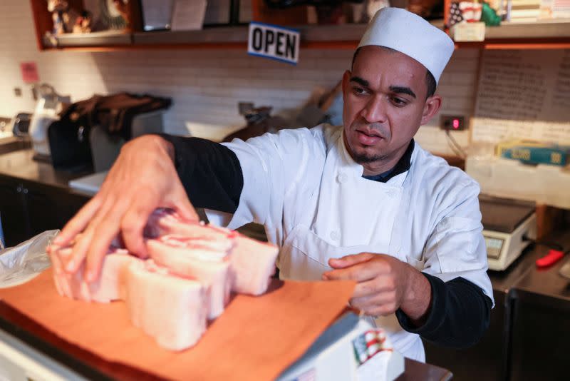 A worker weighs meat at a butcher shop in Manhattan, New York City