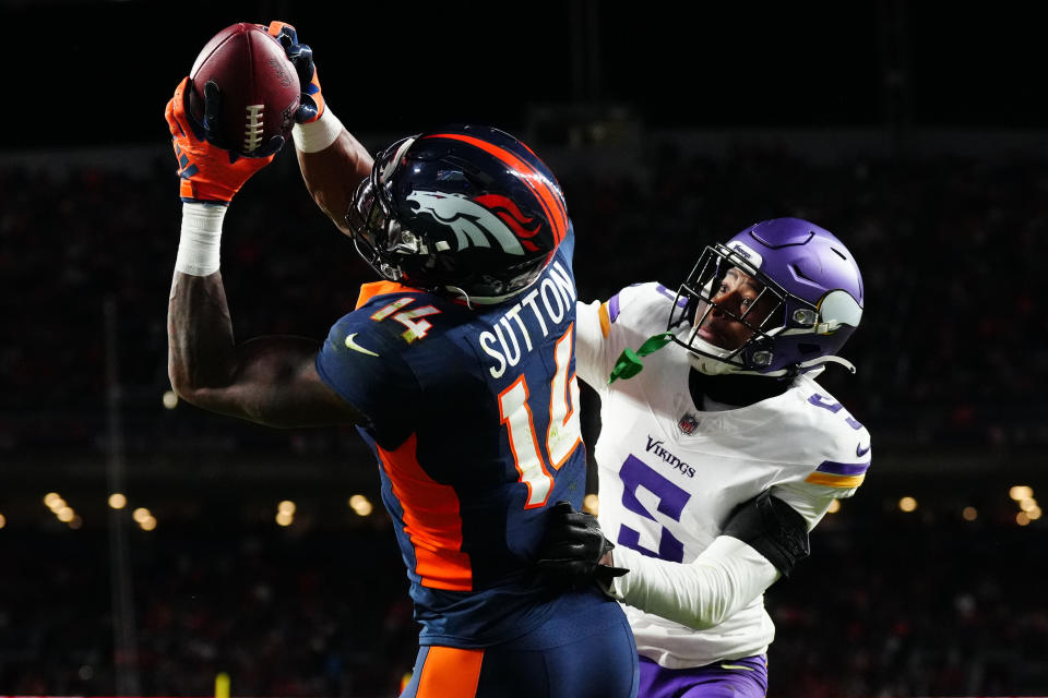 Nov 19, 2023; Denver, Colorado, USA; Denver Broncos wide receiver Courtland Sutton (14) catches a touchdown over Minnesota Vikings cornerback Mekhi Blackmon (5) in the fourth quarter at Empower Field at Mile High. Mandatory Credit: Ron Chenoy-USA TODAY Sports