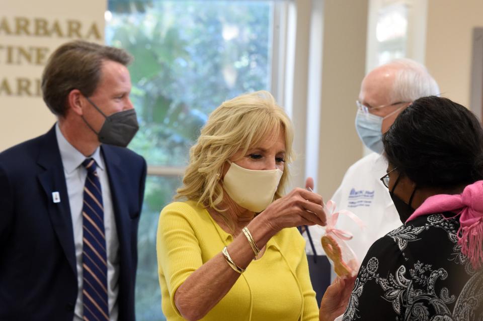 Dr. Ned Sharpless, director of the National Cancer Institute, and first lady Jill Biden, center, arrive at the MUSC Hollings Cancer Center on Monday, Oct. 25, 2021, in Charleston, S.C. Biden heard from researchers and cancer survivors during several hours at the center. (AP Photo/Meg Kinnard)