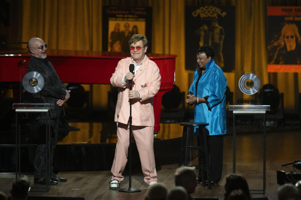 Elton John ríe con Bernie Taupin, izquierda, y la Bibliotecaria del Congreso Carla Hayden, derecha, durante el concierto del Premio Gershwin a la Canción Popular de la Biblioteca del Congreso 2024 en honor a John y Taupin en el DAR Constitution Hall el miércoles 20 de marzo de 2024, en Washington. (Foto AP/Kevin Wolf)