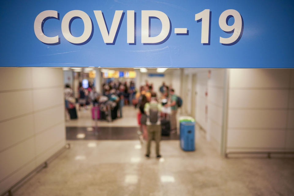 Vacationers arriving in Rome from four Mediterranean countries line up with their suitcases at Rome's Leonardo da Vinci airport to be immediately tested for COVID-19, Sunday, Aug.16, 2020. Italy's health minister issued an ordinance requiring the tests for all travelers arriving in Italy from Croatia, Greece, Malta or Spain. (AP Photo/Andrew Medichini)