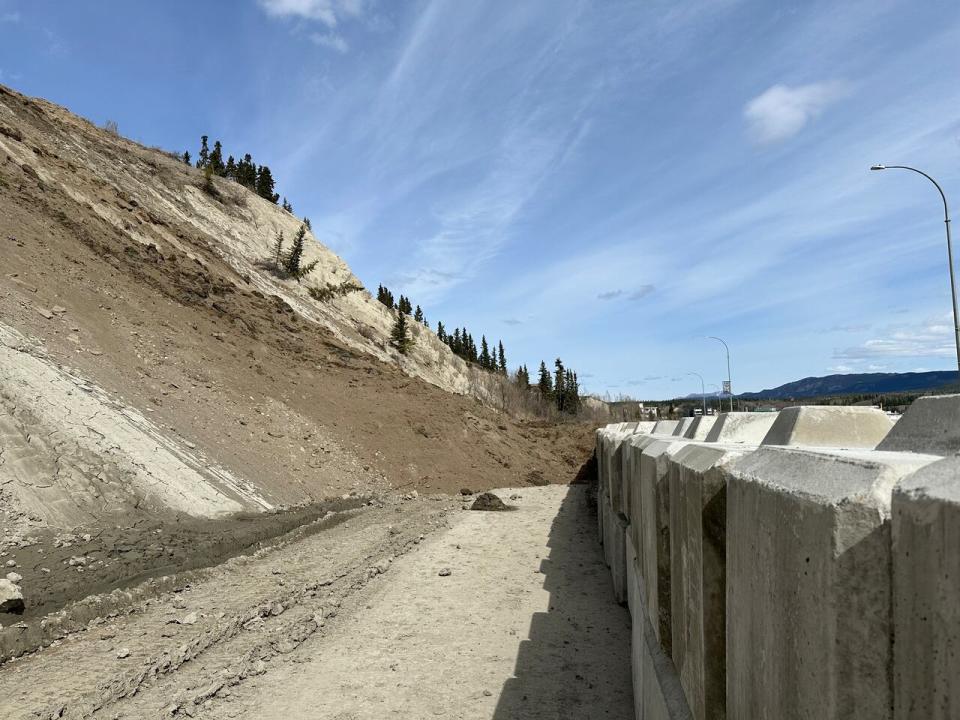 Rock, dirt and debris just reached the top of concrete barriers erected by the city in April. 