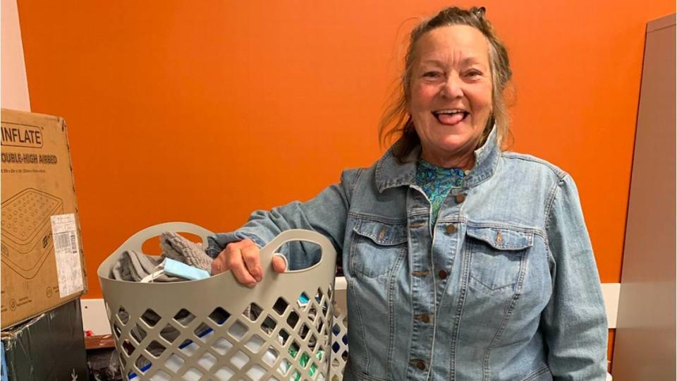 Devonia Colbry, a Navy veteran and former client of 40 Prado Homeless Services Center, stands with her newly received box of bathroom essentials donated by St. Stephen’s Episcopal Church.
