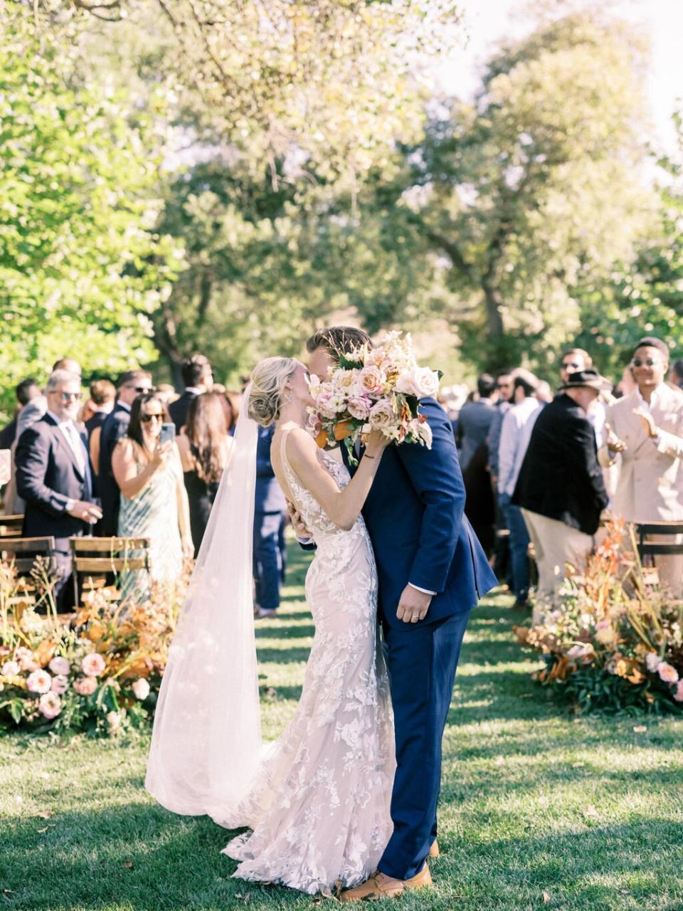 couple kissing at top of the aisle