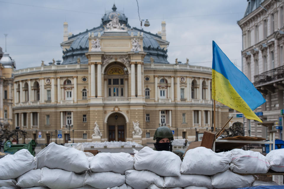 A soldier stands guard behind sandbags near the Odesa National Academic Opera and Ballet Theatre.