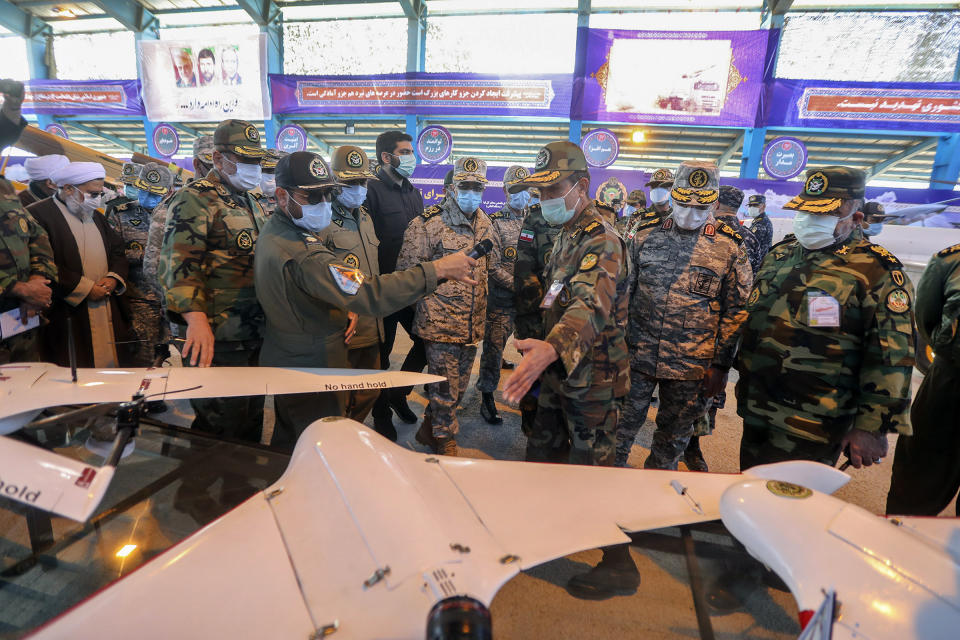 In this photo released Tuesday, Jan. 5, 2021 by the Iranian army, Chief of the General Staff of the Armed Forces Gen. Mohammad Hossein Bagheri, center, listens to an explanation while visiting at a display of drones prior to a drill, Iran. The Iranian military on Tuesday began a wide-ranging, two-day aerial drill in the country's north, state media reported, featuring combat and surveillance unmanned aircraft, as well as naval drones dispatched from vessels in Iran's southern waters. (Iranian Army via AP)