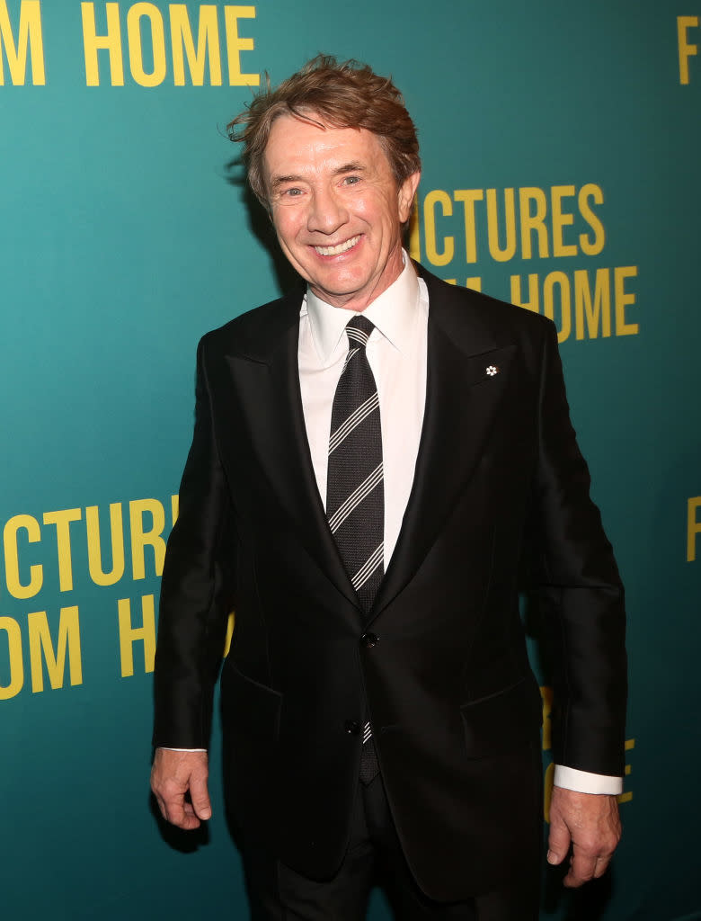 Close-up of Martin in a suit and tie smiling at a press event