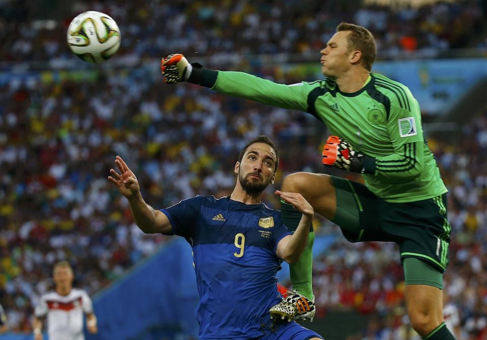 Germany's goalkeeper Manuel Neuer collides into Argentina's Gonzalo Higuain (L) as he clears the ball during their 2014 World Cup final at the Maracana stadium in Rio de Janeiro July 13, 2014. REUTERS/Kai Pfaffenbach (BRAZIL - Tags: SOCCER SPORT WORLD CUP TPX IMAGES OF THE DAY)